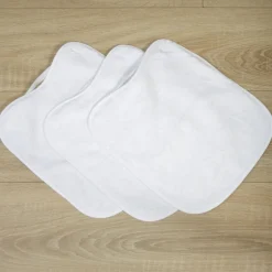 Pack 3 baberos rizo guardería color blanco con elástico. Lavables, exterior de rizo y reverso impermeable. Medidas: 33x29cm
